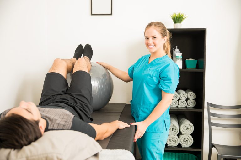 ⁠Eastgate Physiotherapy therapist assisting patient with exercise ball rehabilitation treatment in a modern physiotherapy clinic